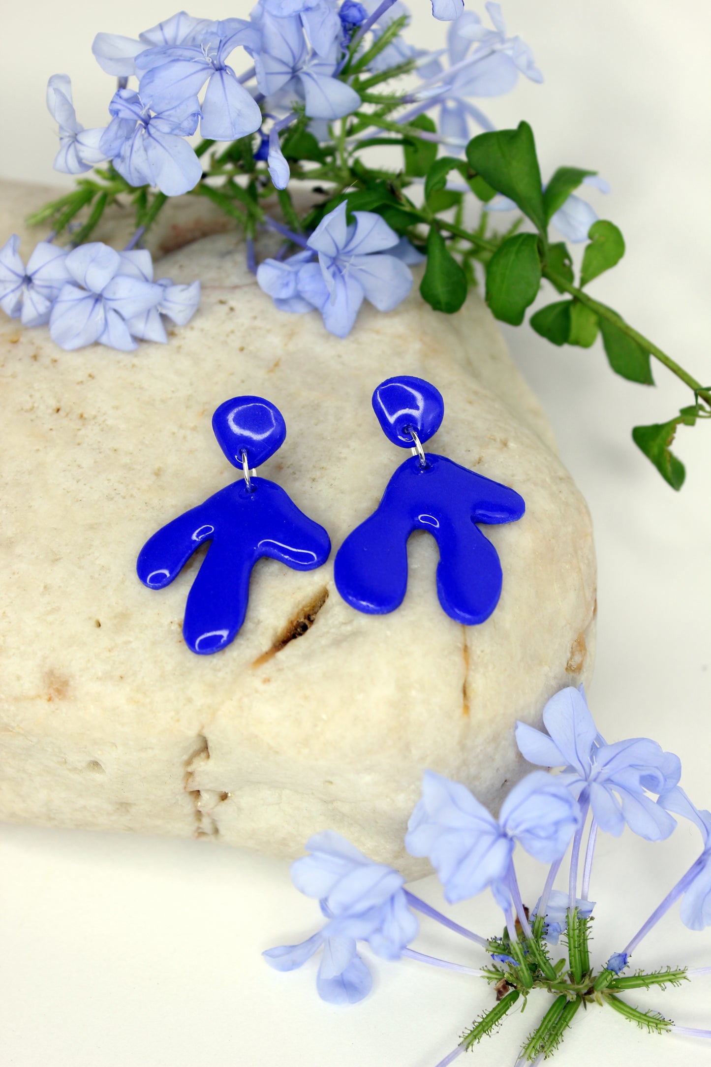 Boucles d'oreilles bleu Klein inspirées par les œuvres de Henri Matisse et de Yves Klein, de forme abstraite évoquant les algues ou les feuilles, en argile polymère, résine et argent plaqué. Pièces uniques fabriquées à la main sur la Côte d'Azur.