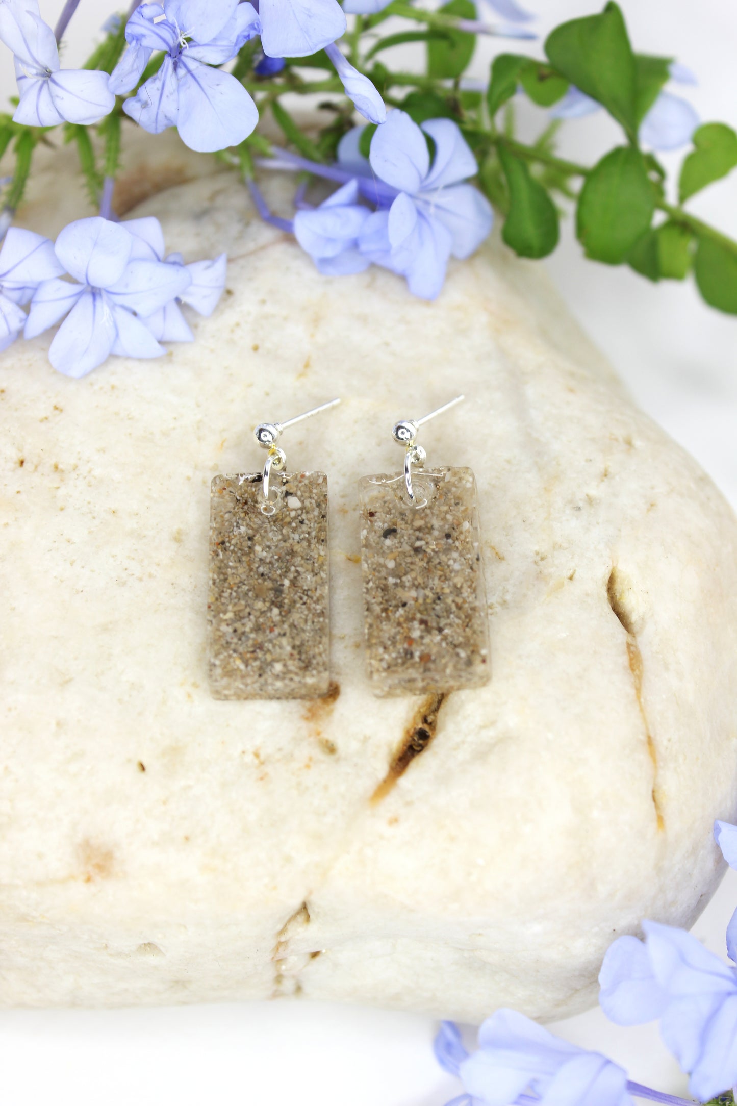 Boucles d'oreilles rectangulaires en résine transparente et inclusion de sable. Entièrement fabriquées à la main sur la Côte d'Azur, en résine, sable et argent plaqué.