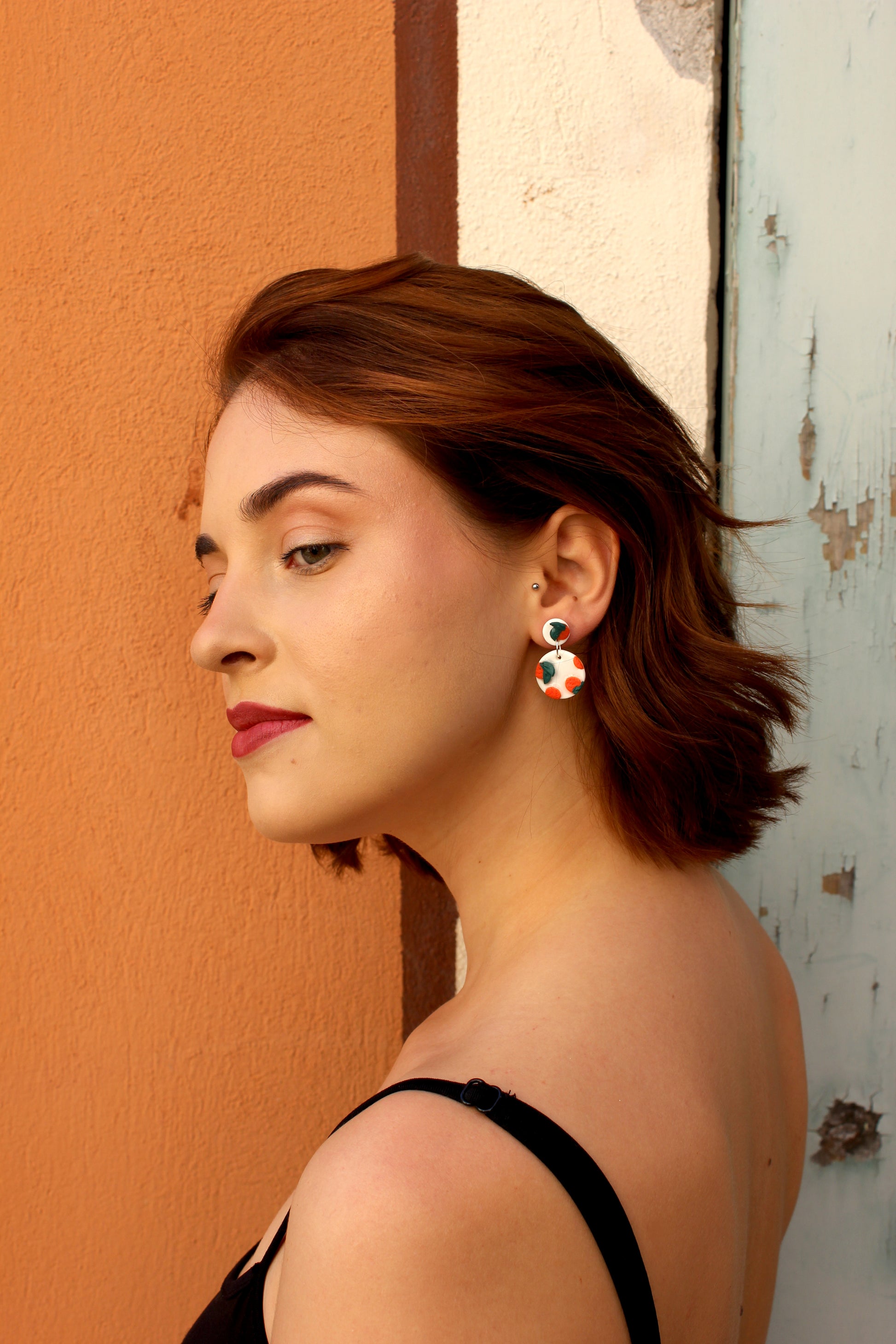 Boucles d'oreilles blanches vernies avec oranges sculptées, inspirées des agrumes de la Méditerranée. Entièrement fabriquées à la main sur la Côte d'Azur, en argile polymère, résine et argent plaqué.